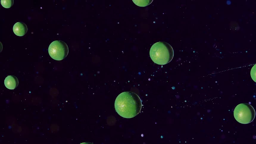 Green spheres move from left to right orbiting an outer spacelike background in this computergenerated animation