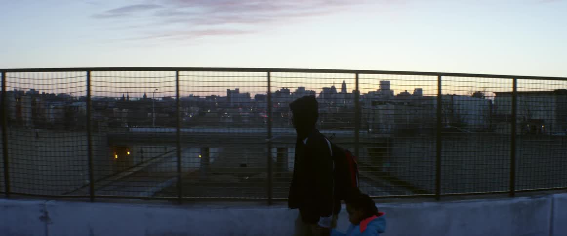A man and child walk along an overpass