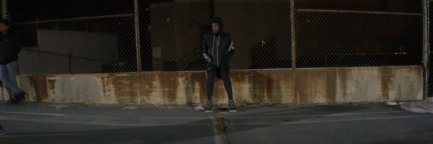 A man watches people play basketball