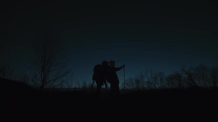 Two people hiking in the wilderness during the night time