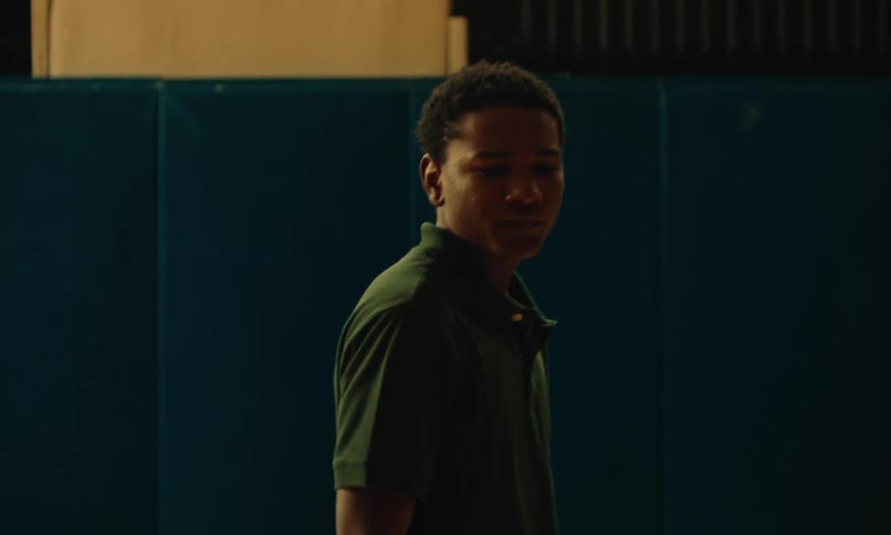Teenage boys playing basketball in a gymnasium as one boy is upset he didnt get the ball and walks away sad