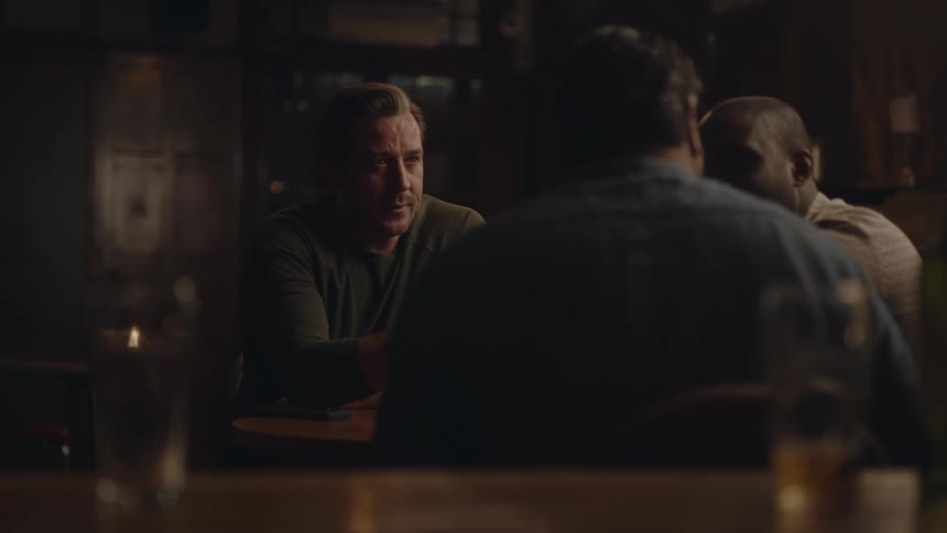 Friends sit together in pub talking and drinking