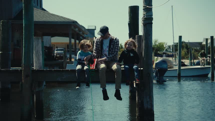 A father and his sons are fishing on the pier