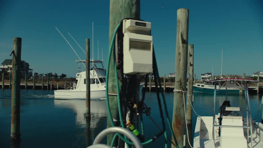 A boat is driving near a dock in the water