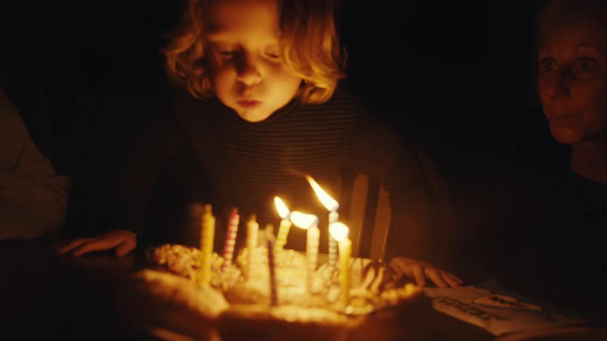 A child blows out birthday candles