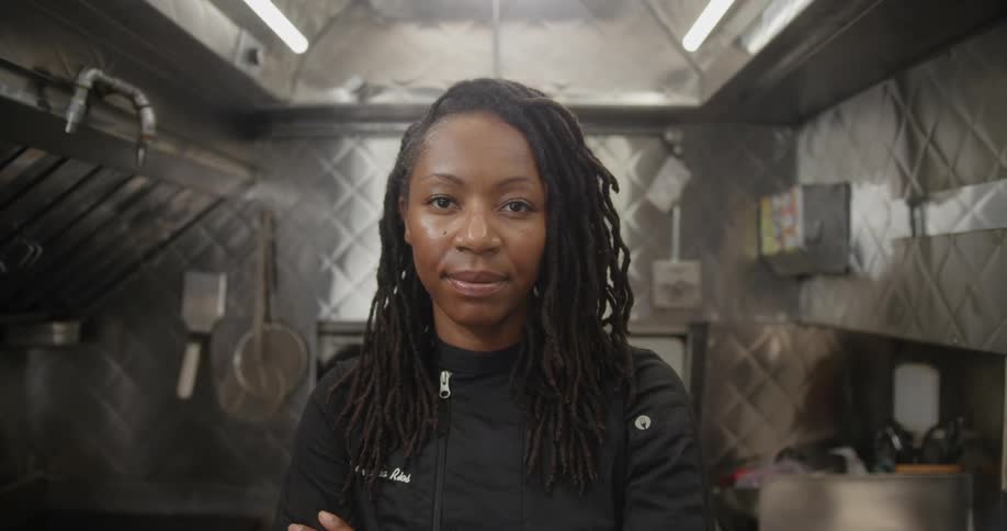 Chef standing in the middle of the kitchen and smiling