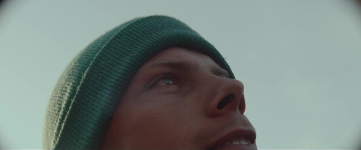 A man wearing a cap while staring at the sky