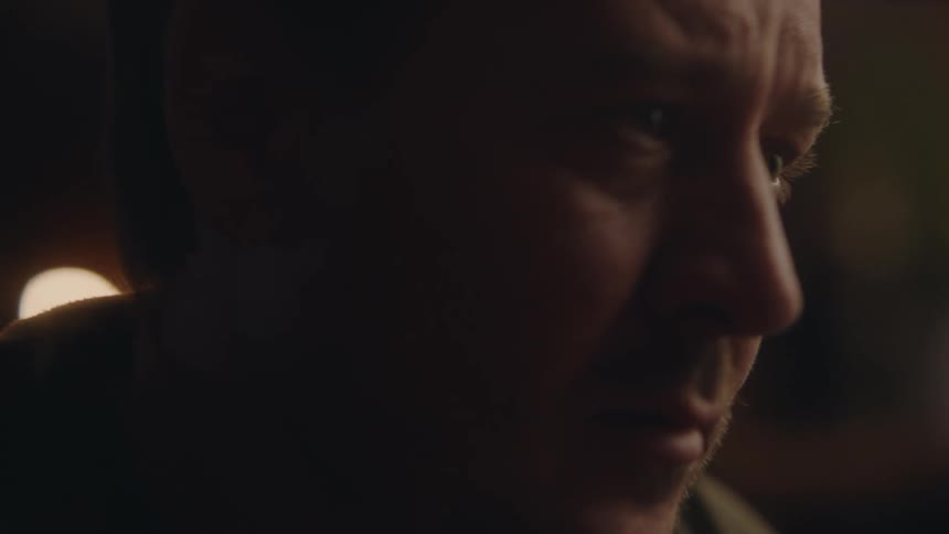 An extreme close up of a mans face as he looks stressed and is wiping away tears before taking a drink