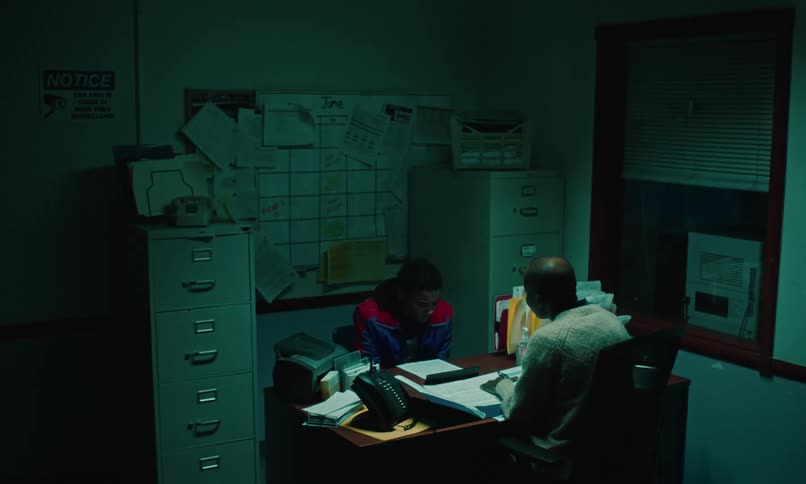 Teenage boy sitting across from a female sitting at her desk in her office