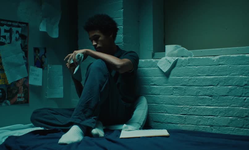 A man reads letters in his prison cell