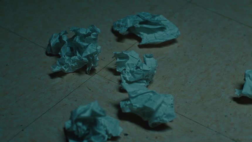 Crumpled paper on the floor of a dimly lit room