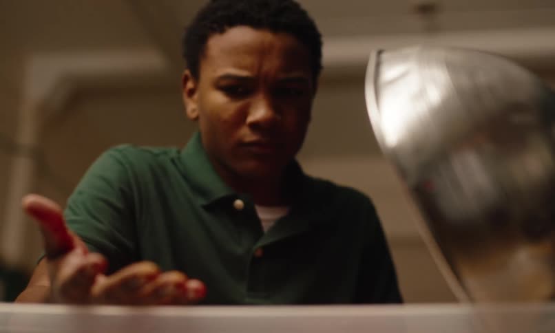 Youth examines his dirty hand after sticking it into a tub