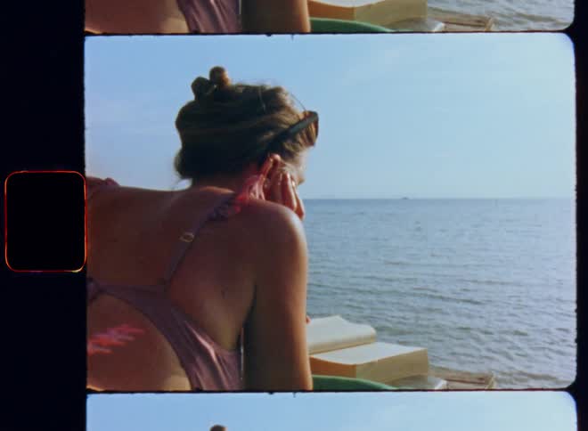 A woman is reading a book by the water