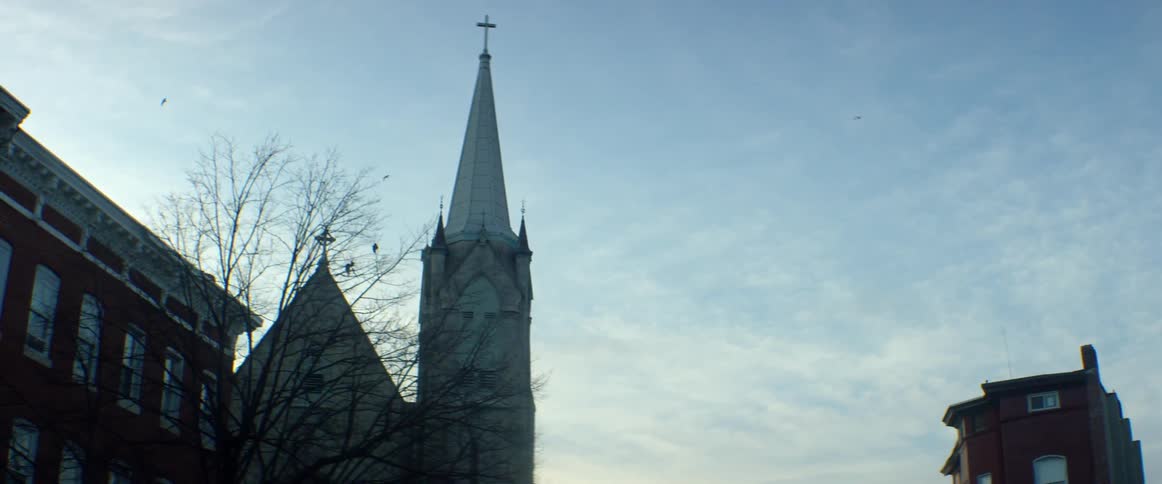 Birds fly around a church in the sky