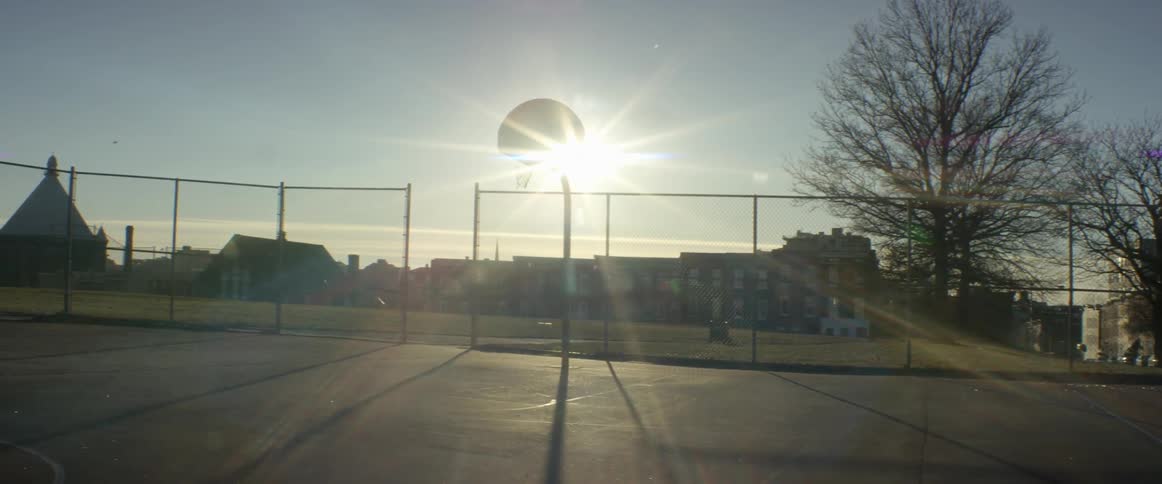 Sun shining behind a basketball backboard