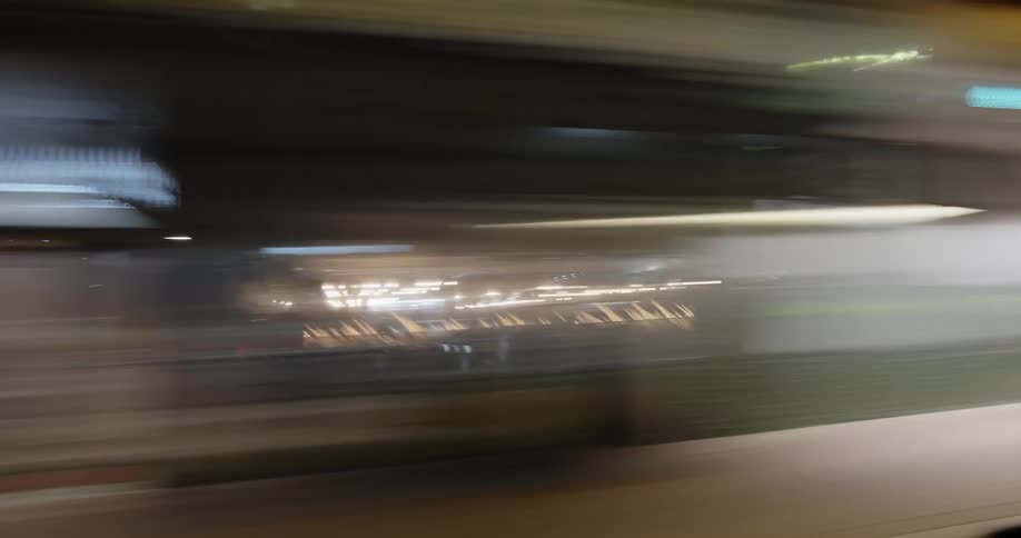 Sidemirror contrasts with building lights streaking by at night