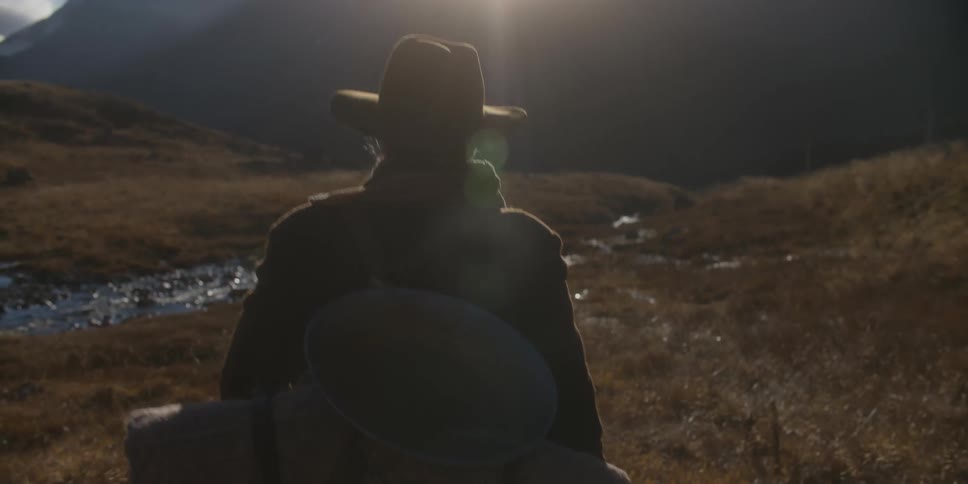 A man is hiking near a mountain range