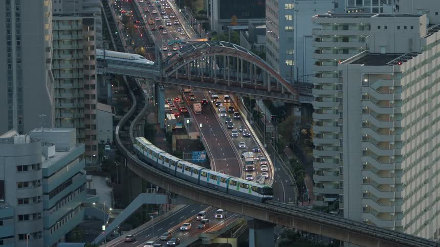 Dense traffic travels along a freeway in a metropolis during the day