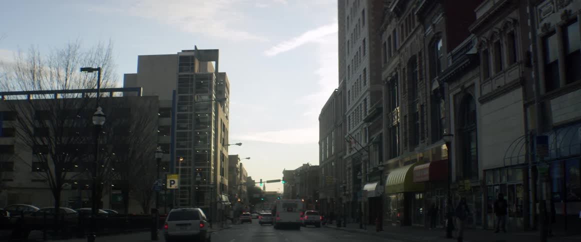 Vehicles drive down a city street