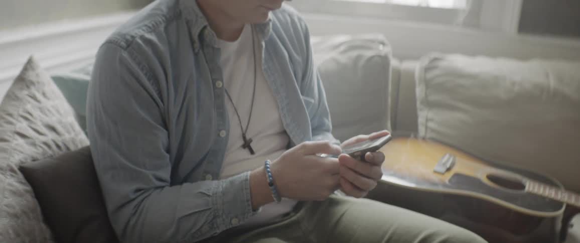 A young bespectacled man is on a phone