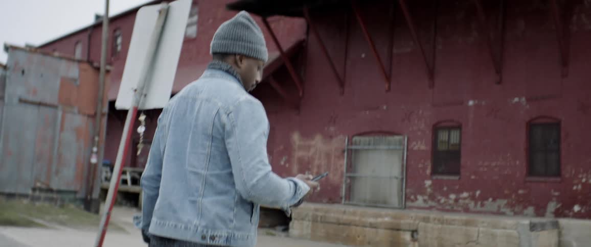 A man walks up to the building holding his phone