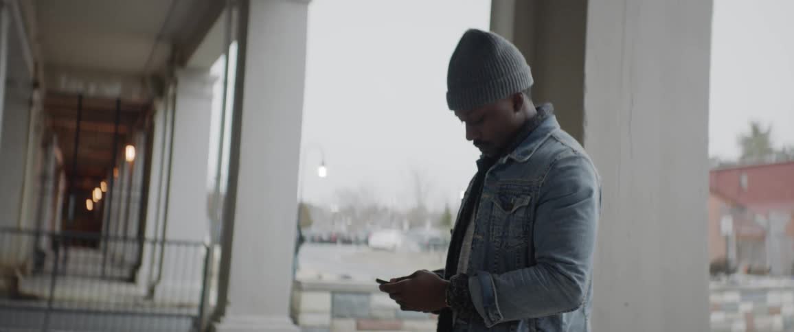 A man is outside looking at a phone