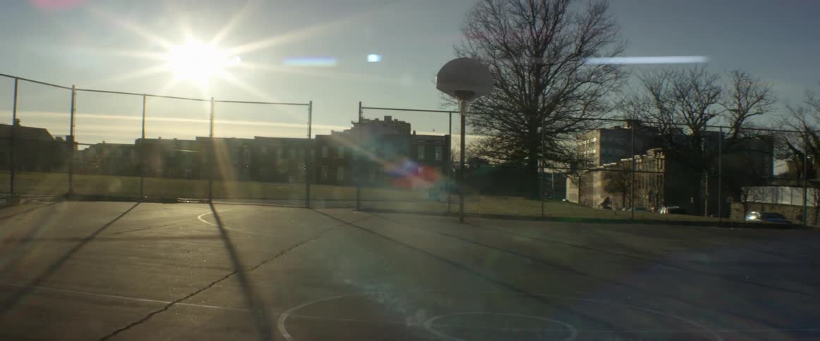 The sun is setting over the basketball court