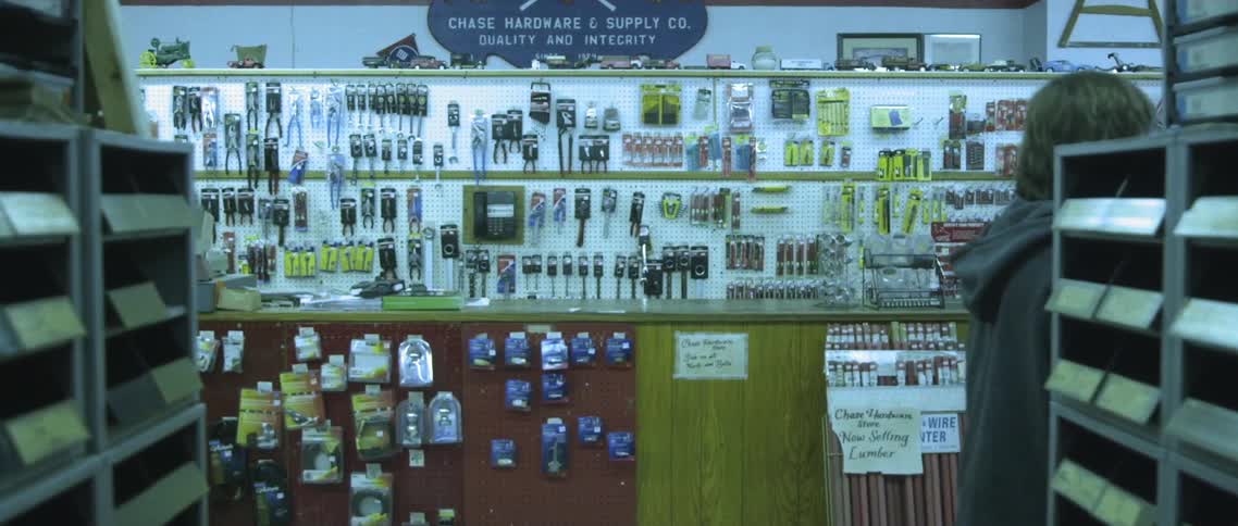 A man walks through a store and around the shelves