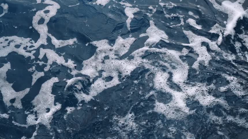 Moving water creating small waves and bubbles