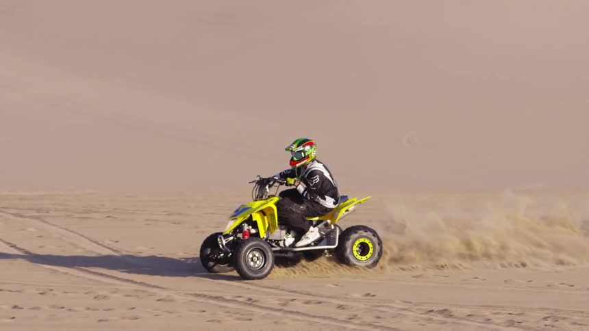 A person is riding a four wheeler in the desert
