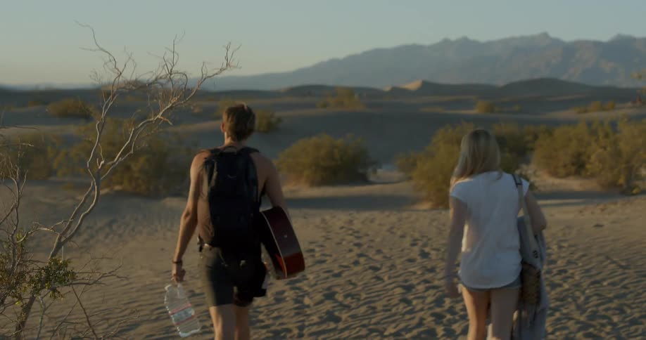 Two people are walking in the desert