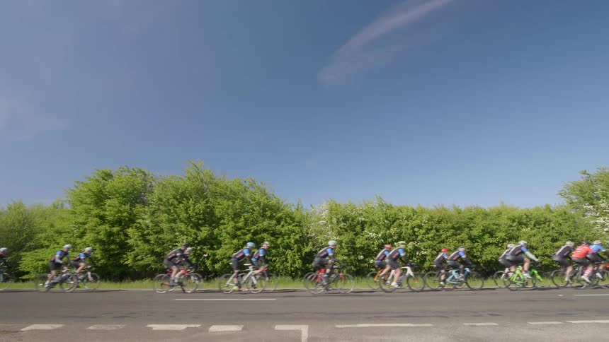 A group of cyclists travel down a road