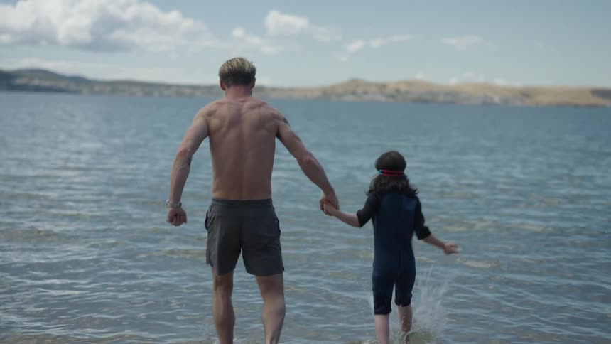 Father and daughter playing at the sea on the beach