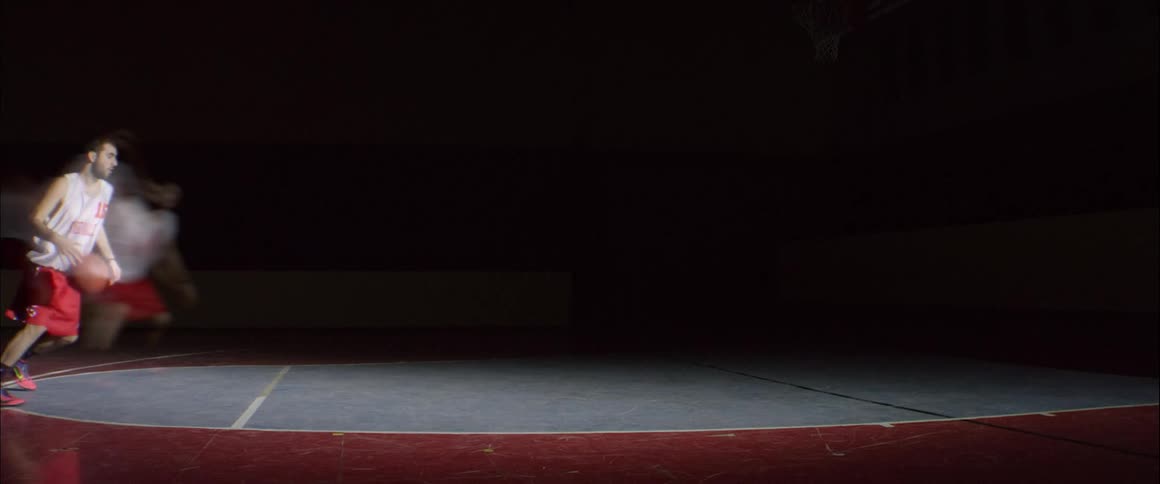 A man dribbling a basketball on a court and there are streaks behind him