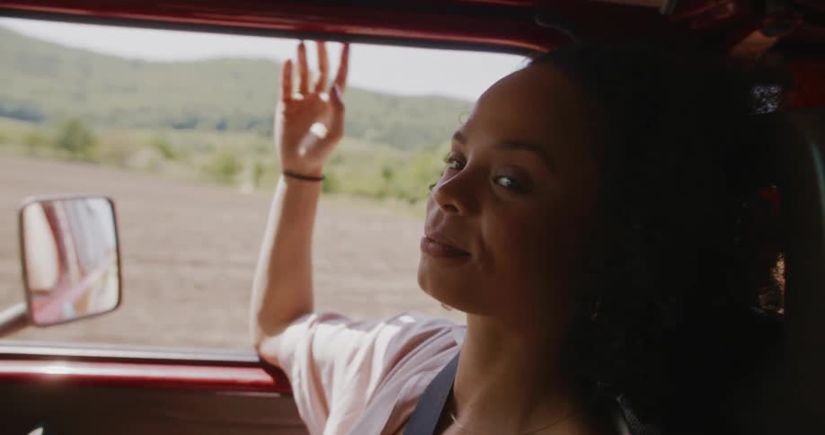 Woman traveling in a moving car with mountain landscape
