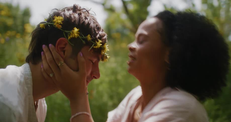 Close up of a man and woman as the woman kisses the man on the forehead smiling and laughing together