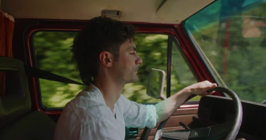 A man driving a vehicle argues with a passenger that is out of frame