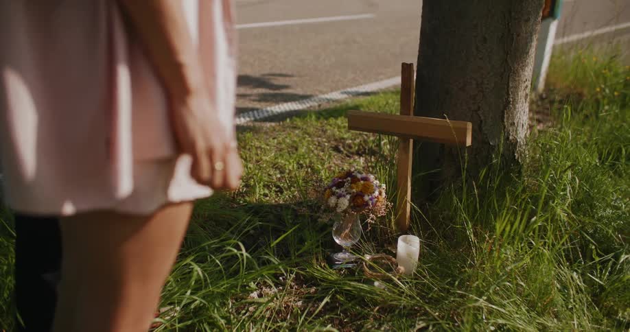 A woman is standing near a cross