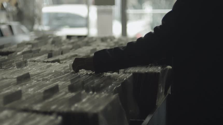 Close up of a man looking through records stacked together in a record store