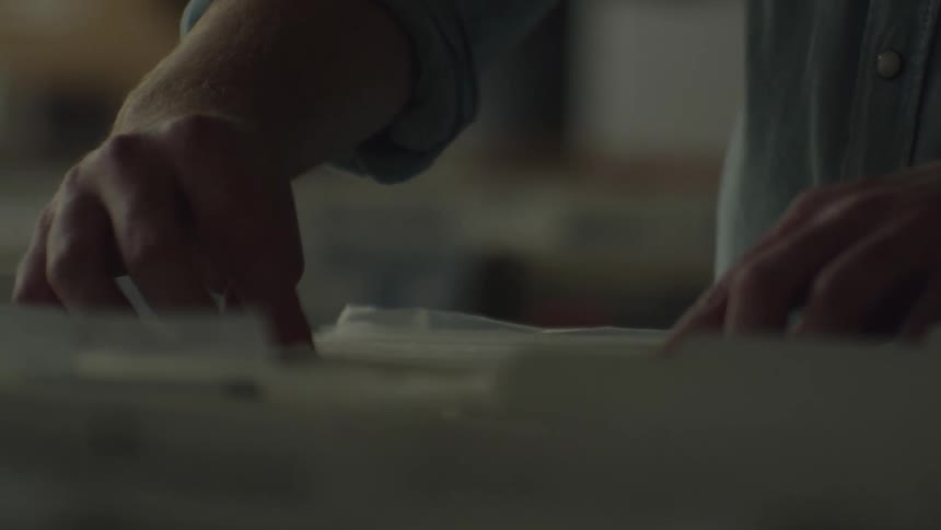 A man on a work bench taking measurement