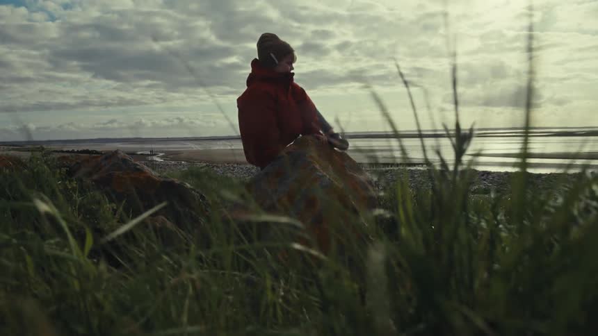 A child climbs on a rock on the beach