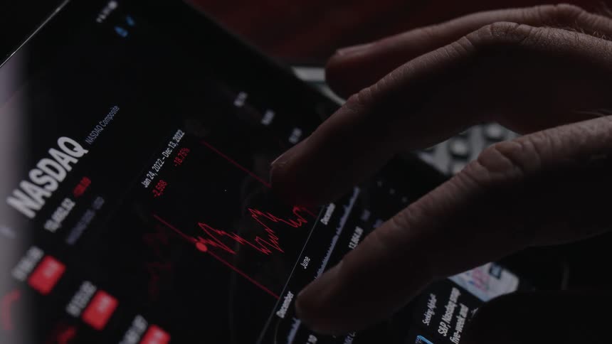 A close up of a mans fingers as they move a graph on their tablet screen