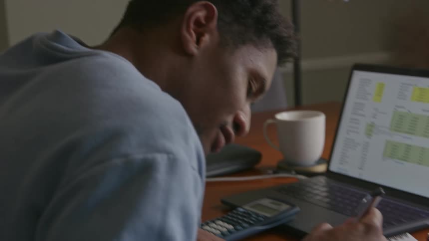 A man takes some notes at his desk