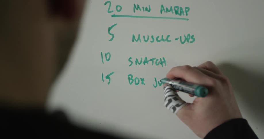 A person is writing on a whiteboard