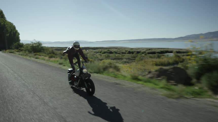 A man races on his motorcycle while standing