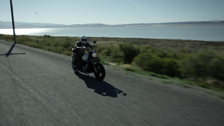 A person races on a motorcycle then stands