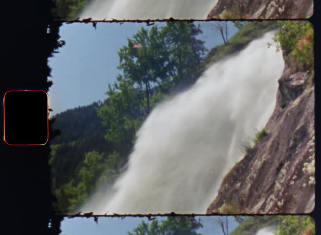 A waterfall from a mountain and trees and a clear cloudy