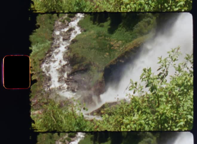 The waterfall pours into a stream