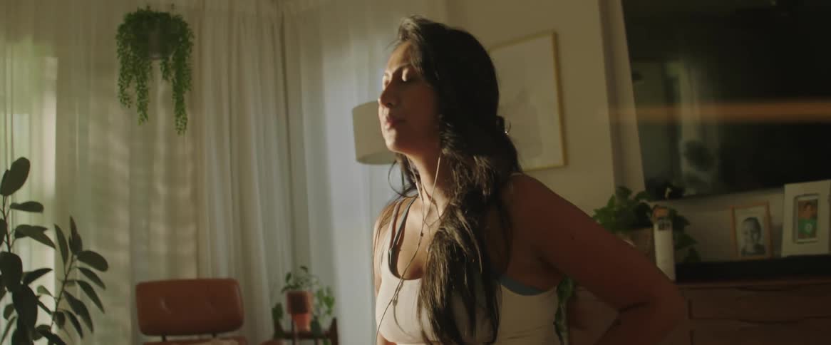 Pregnant woman practicing yoga listening to music
