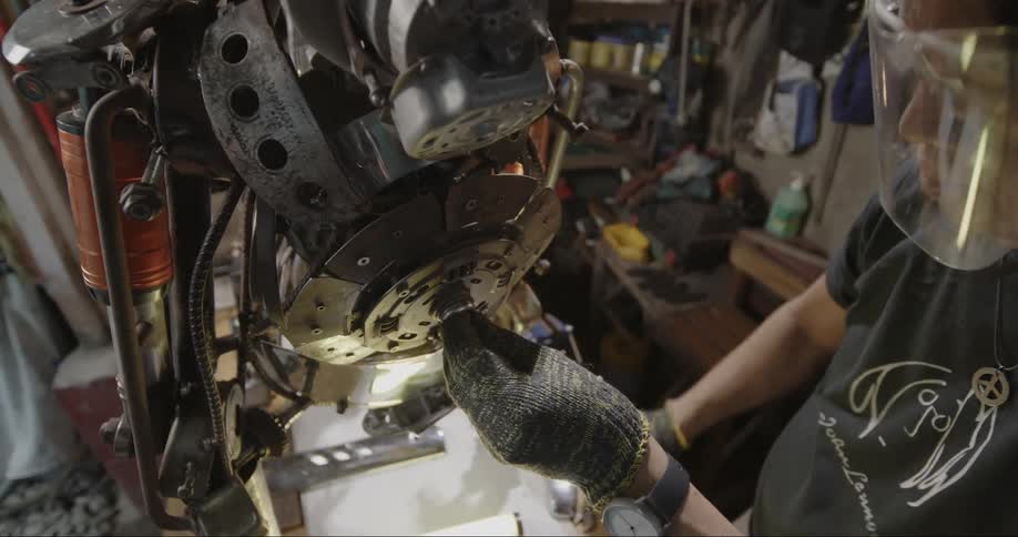 Person wearing gloves fixing a machine